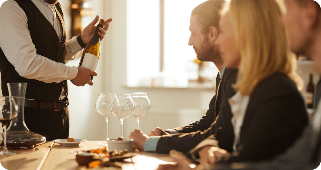 a group of people standing next to a glass of wine