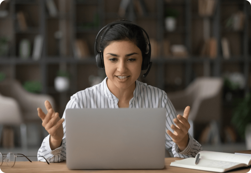 a person sitting at a table in front of a laptop