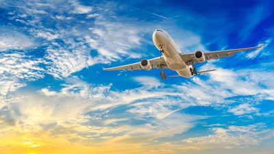 a large airplane flying through a cloudy blue sky