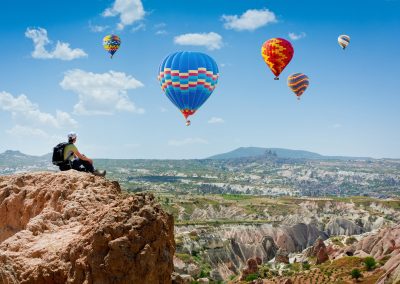 a group of people flying kites on a rocky hill